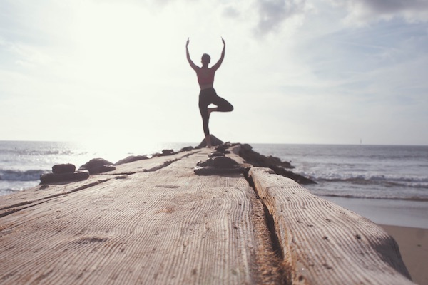 Auszeit für Mama - Frau macht Yoga am Meer